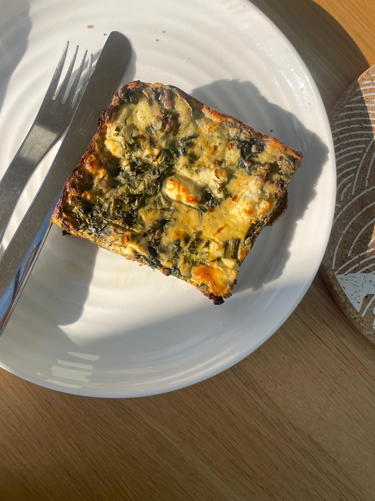 A slice of savoury frittata on a white plate