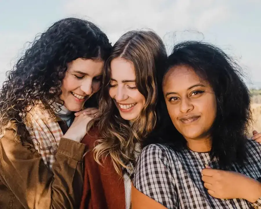 Three women laughing together outdoors
