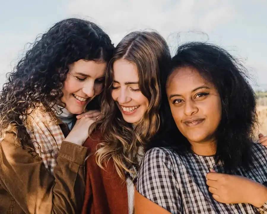 Three women laughing together outdoors