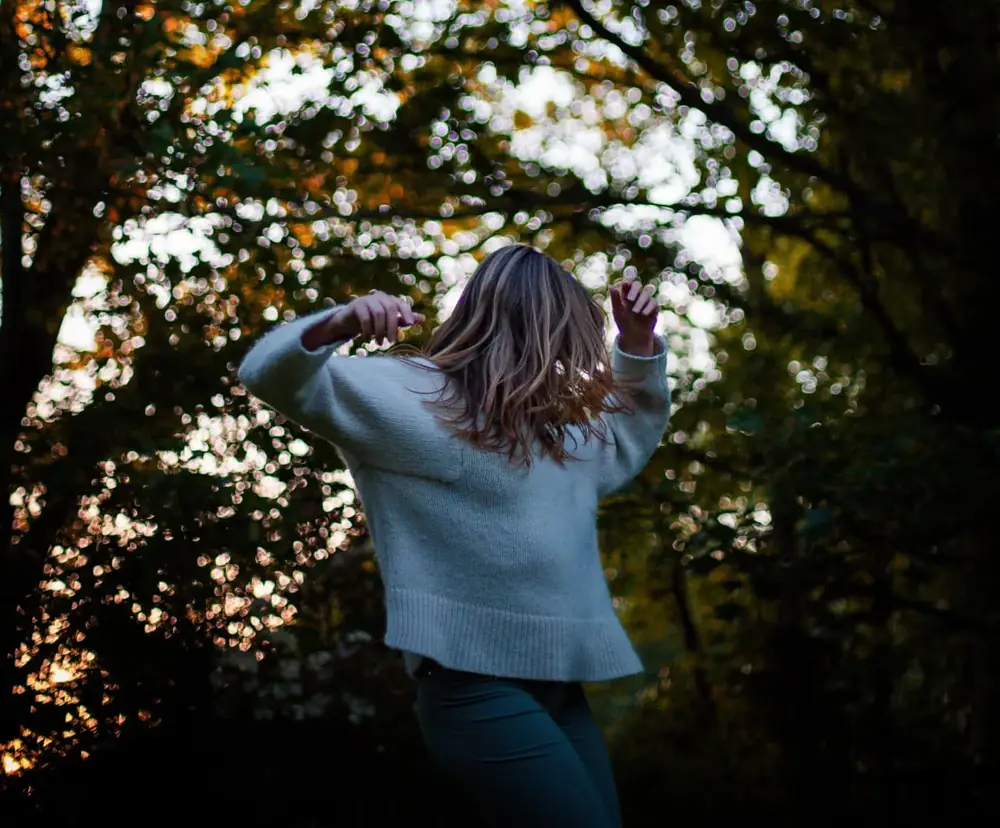 Florence Seck moving freely beneath autumn trees